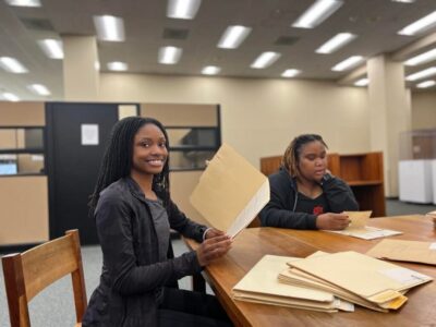 Two women sit at a table in the library