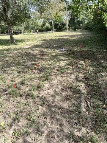 Rows of possible unmarked graves marked with flags [Photo © Evelyn Todd, 2023]