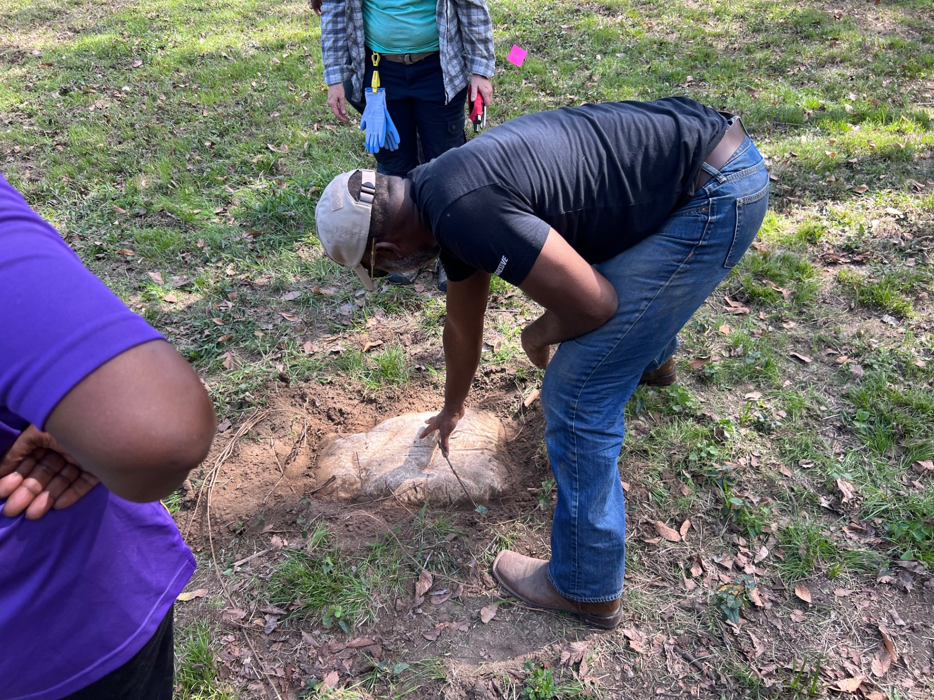 Gregory Newton leans over to examine one of the many field stones uncovered in the cemetery [Photo © T. DeWayne Moore, 2023]