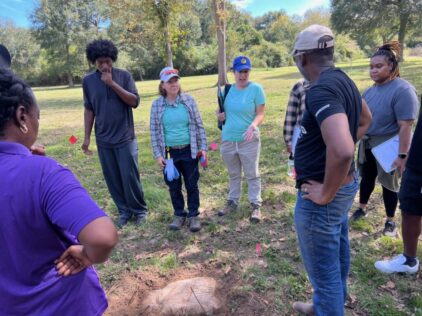 Nesta Anderson and Melanie Nichols explaining to students and alumni the process of recording unmarked burials in a cemetery [Photo © T. DeWayne Moore, 2023]