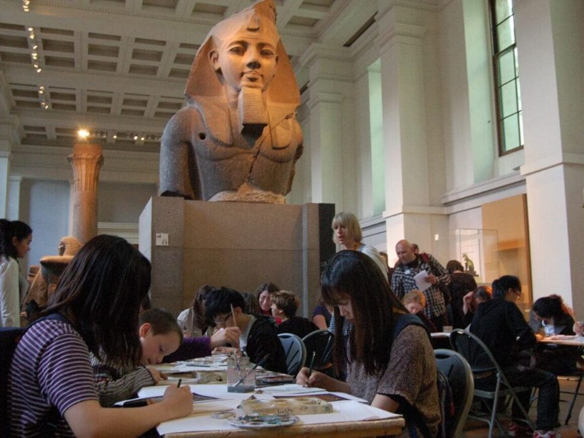 A group of students working on an assignment in front of an Egyptian monument