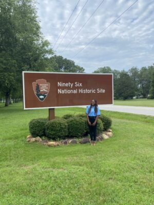 PVAMU student and National Park Service intern Ocean Dunbar stands next to the official sign of Ninety Six National Park in South Carolina