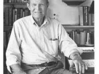 An older, white man sitting in his office