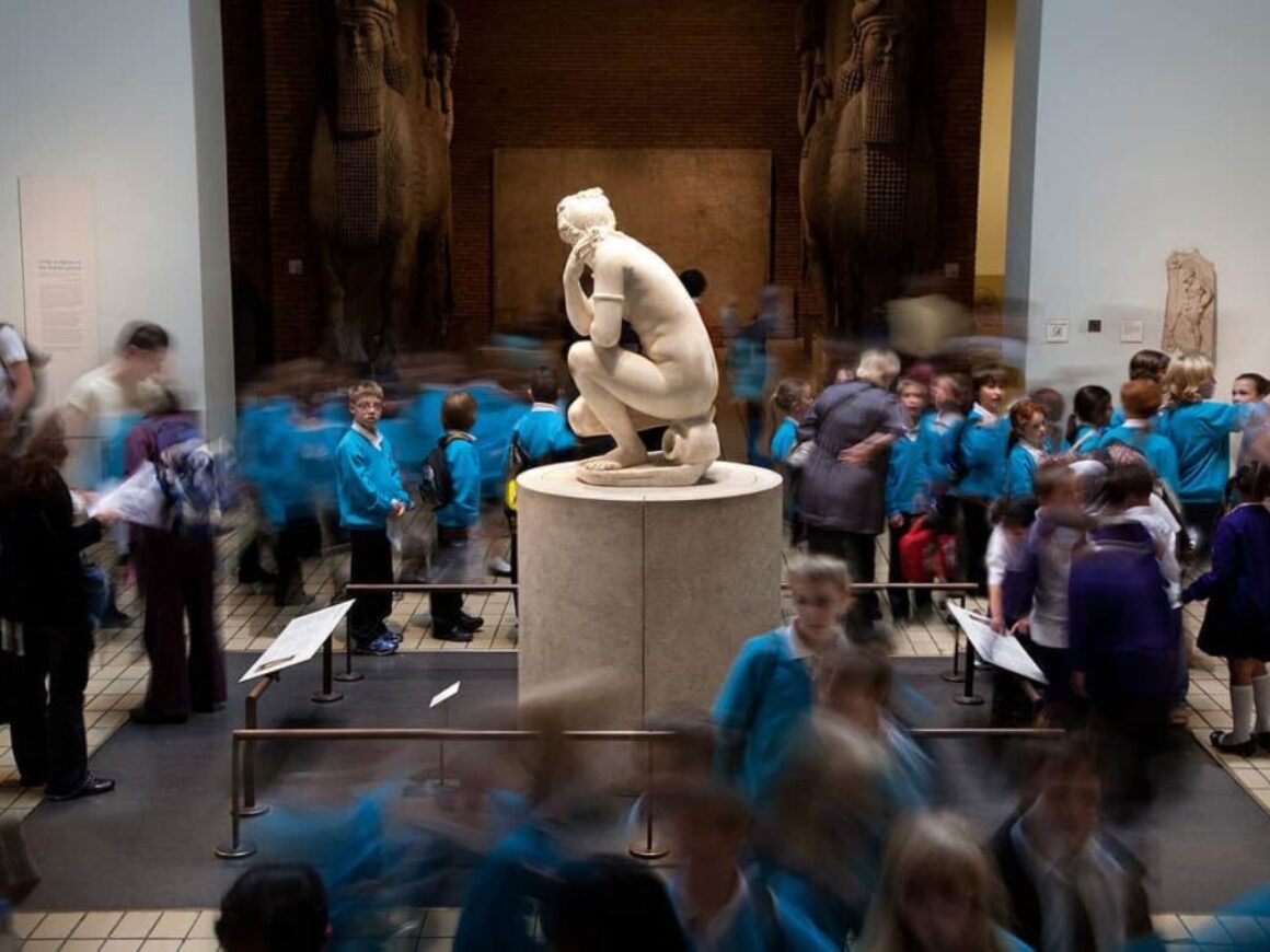 Students visiting a museum with a statue