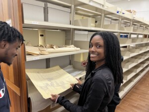 Archival Assistants Hannah Harden & Noah Jackson examine a map of the city of Prairie View from the 1980s