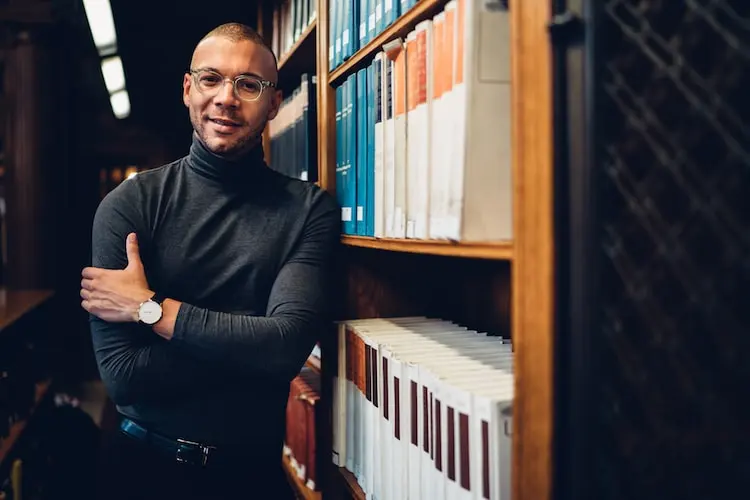 An unidentified man standing next to the book stacks [Photograph by Unknown photographer, 2021]